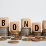 Wooden blocks spelling "BOND" stacked on coins, symbolizing bond investments and financial strategies relevant to small business accounting.