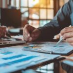 Small business owner and accountant reviewing financial reports together, illustrating success with flat fee CPA services