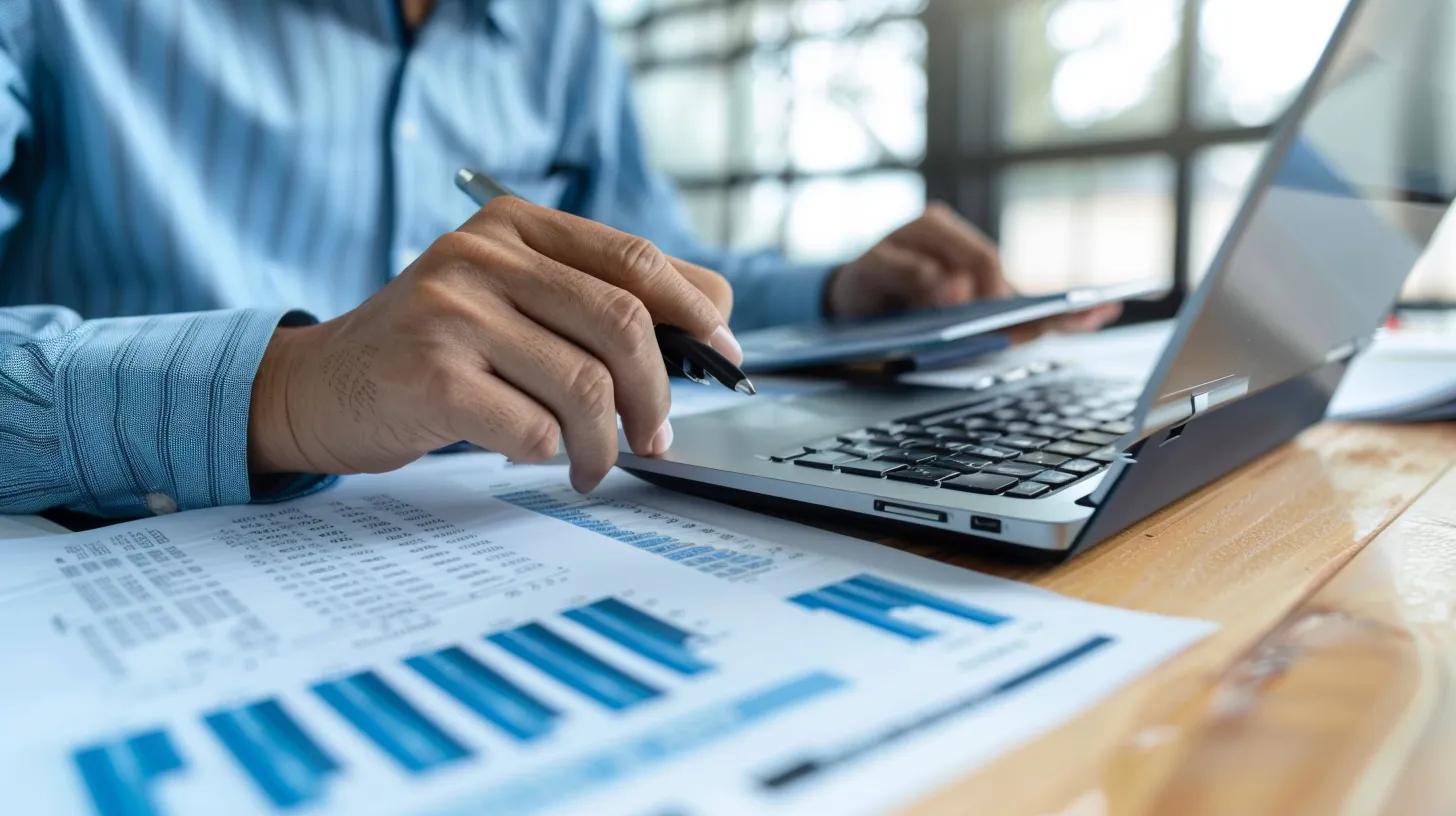 Small businesss owner reviewing financial documents with a calculator and laptop representing transparent flat rate pricing